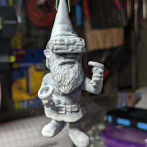 A little gnome figure with a coat of primer He's wearing a VR headset